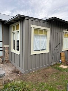 Gray paneled exterior with light-colored window frames and yellow-tinted windows.