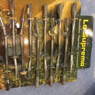 A row of stainless steel straws on a card that says la suprema