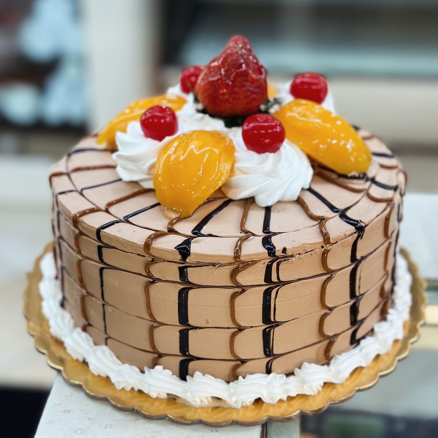 A chocolate cake with whipped cream and fruit on top
