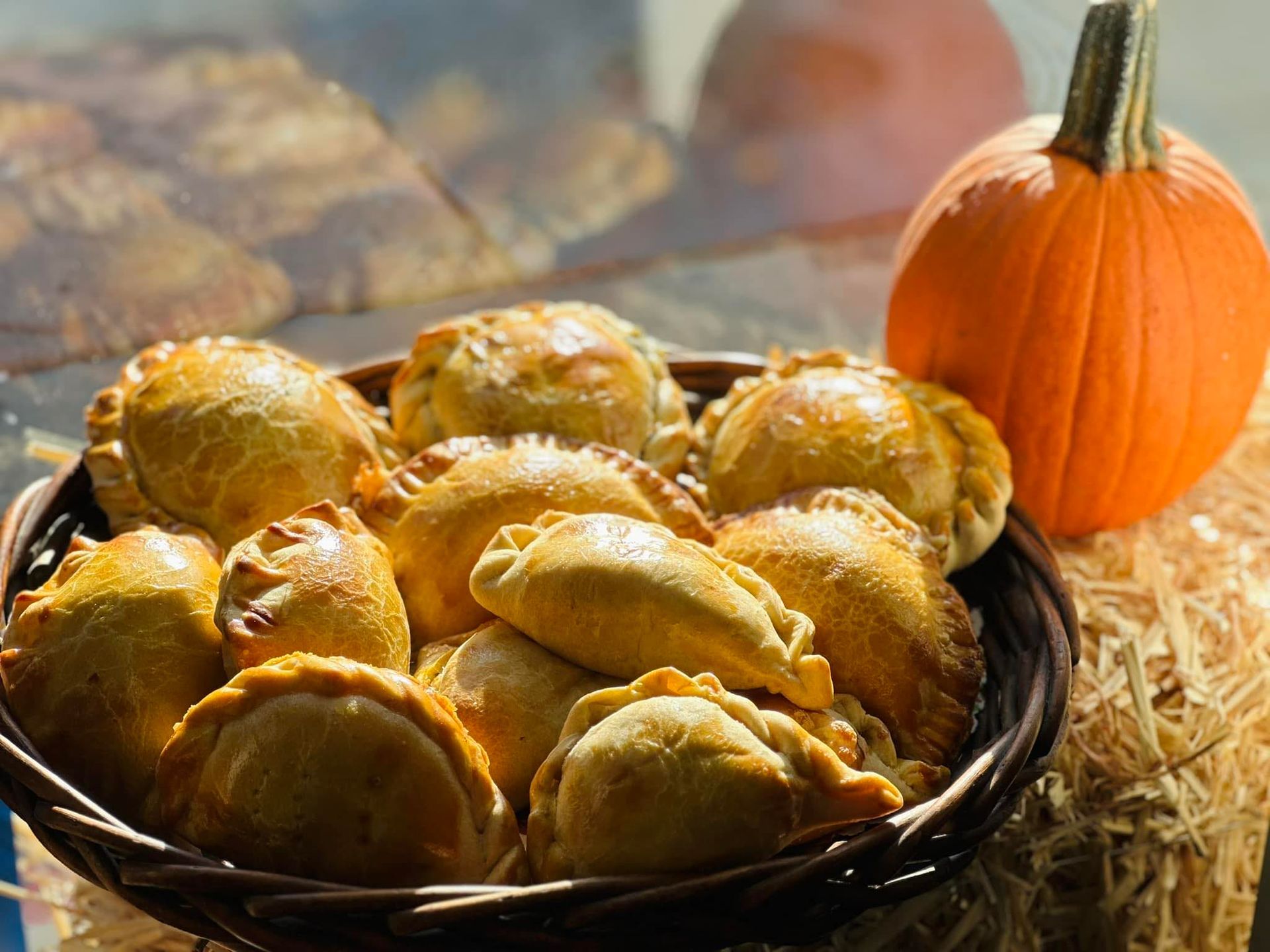 A basket filled with pastries next to a pumpkin.