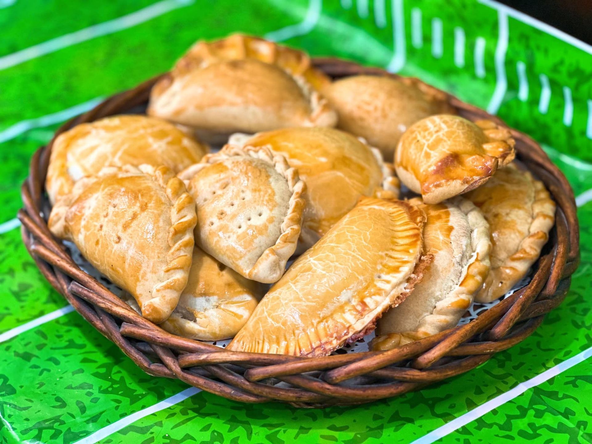 A basket of pastries is sitting on a green table.