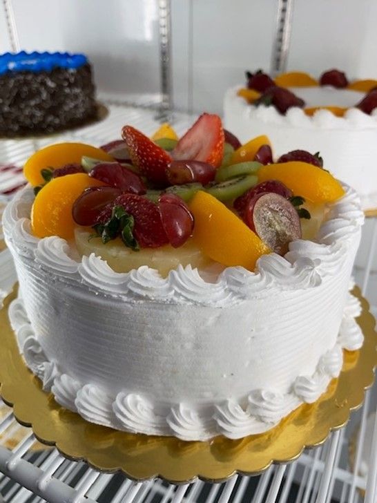 A cake with fruit on top of it is sitting on a table.