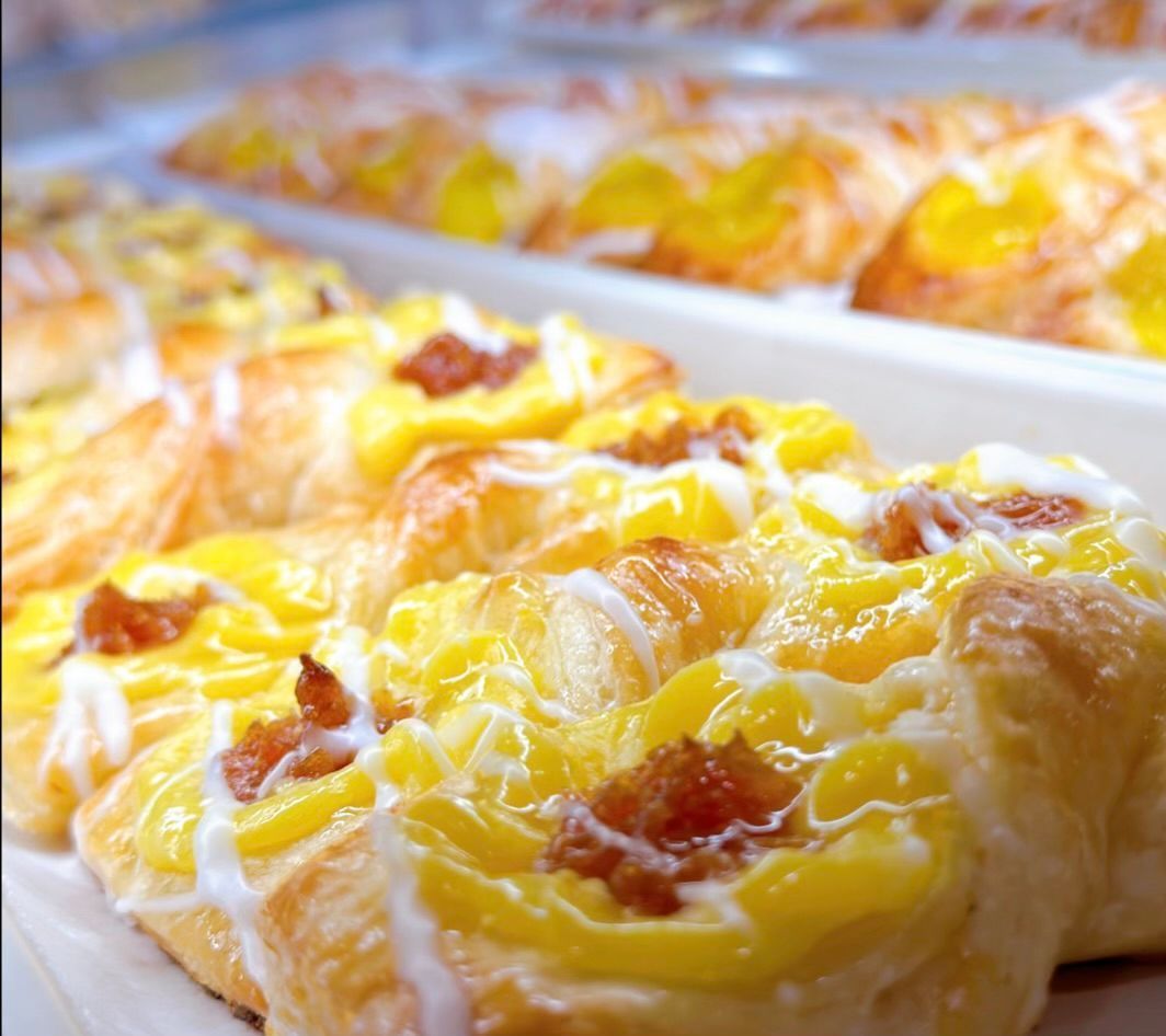 A bunch of pastries with yellow frosting on them