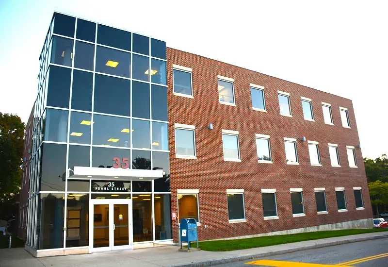 Modern brick office building with glass entrance and blue doors