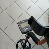 Un metal detector è posizionato su un pavimento piastrellato.