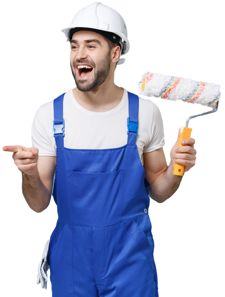 Happy painter in blue overalls and white hard hat, pointing and holding paint roller.