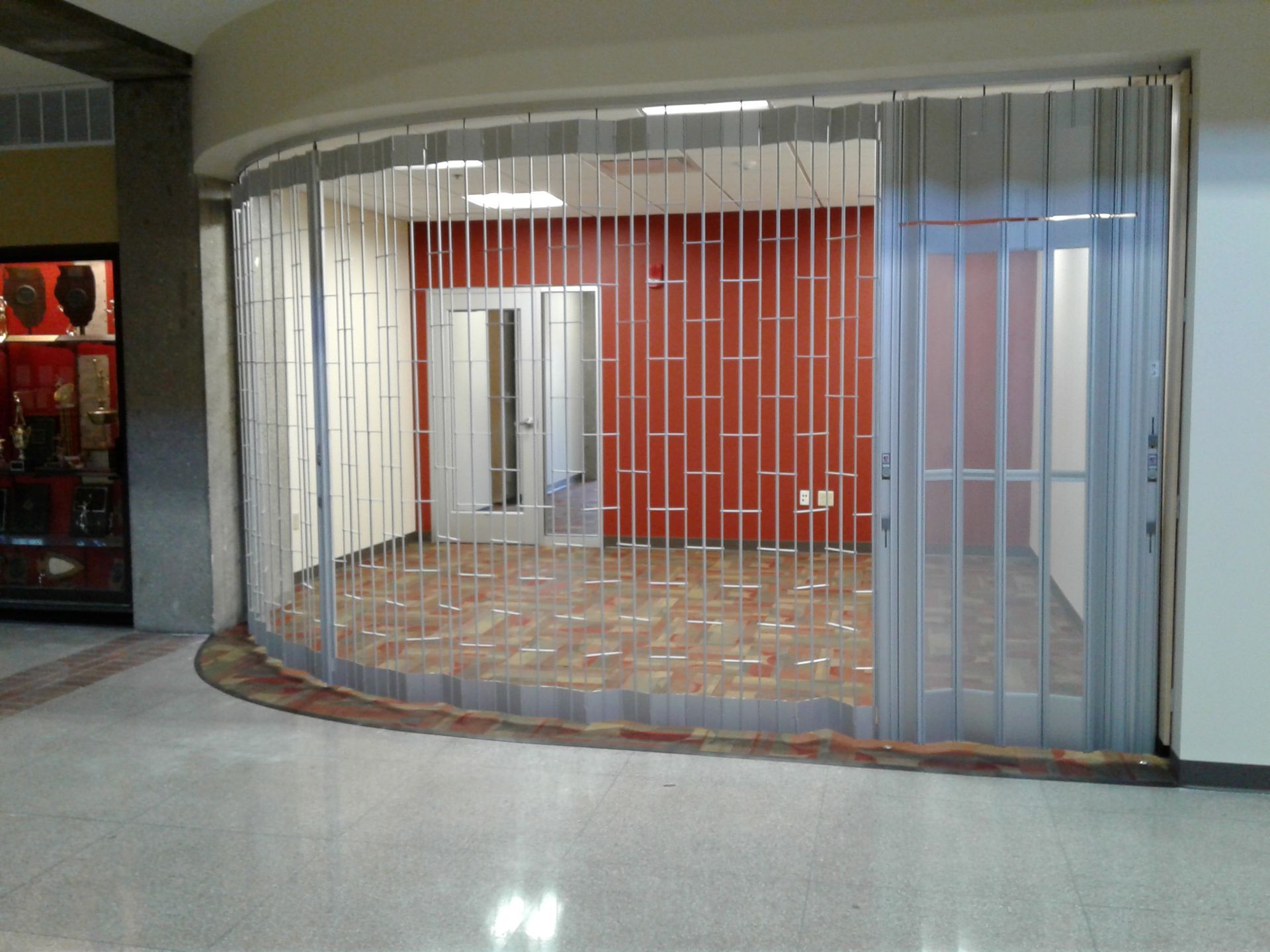 An empty room with a sliding glass door and a red wall