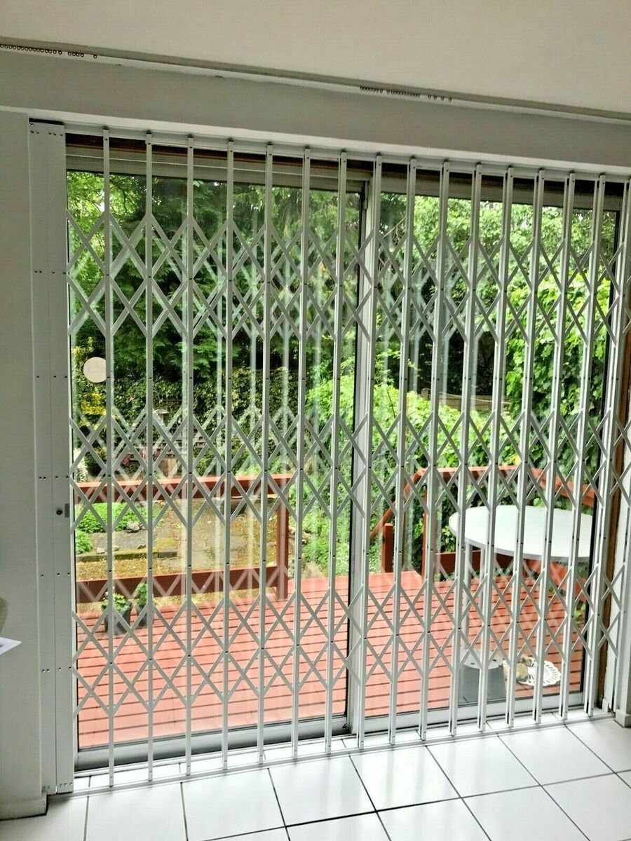 A sliding glass door with a metal gate on it