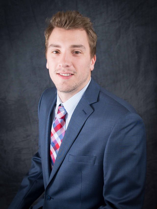 A man in a suit and tie is smiling for the camera.