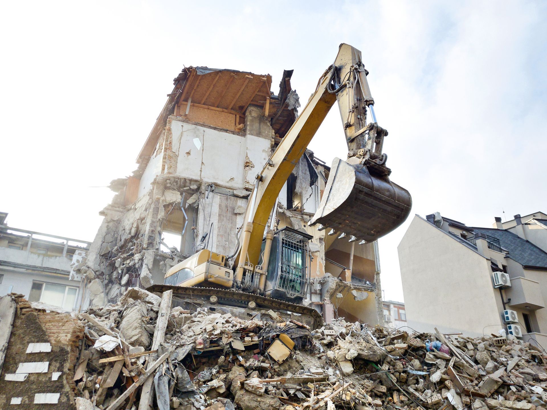 Une excavatrice démolit un bâtiment avec un grand godet.