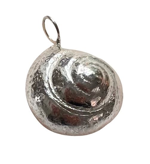 A person is holding a silver pendant with a flower design on it.