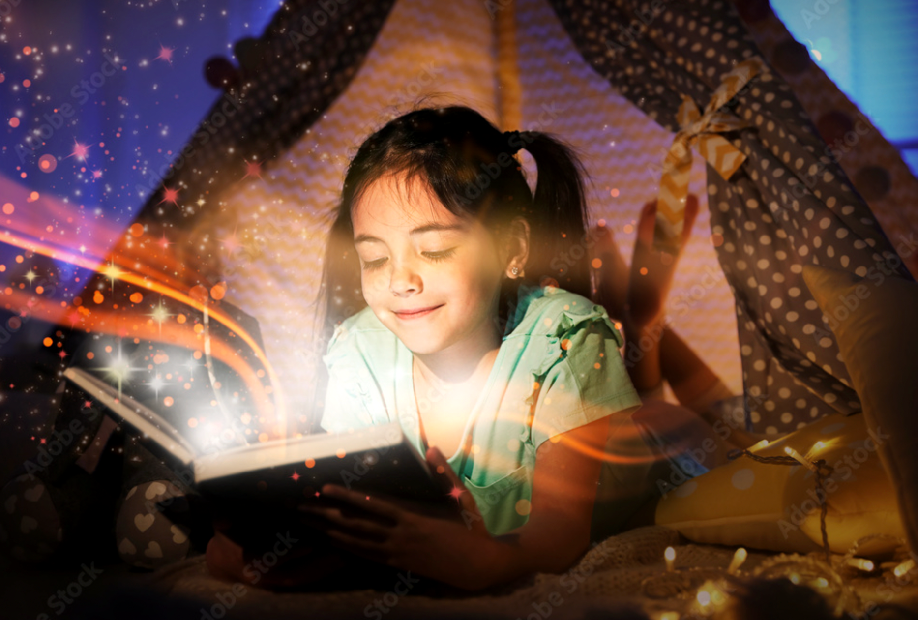 A little girl is reading a book in a tent.