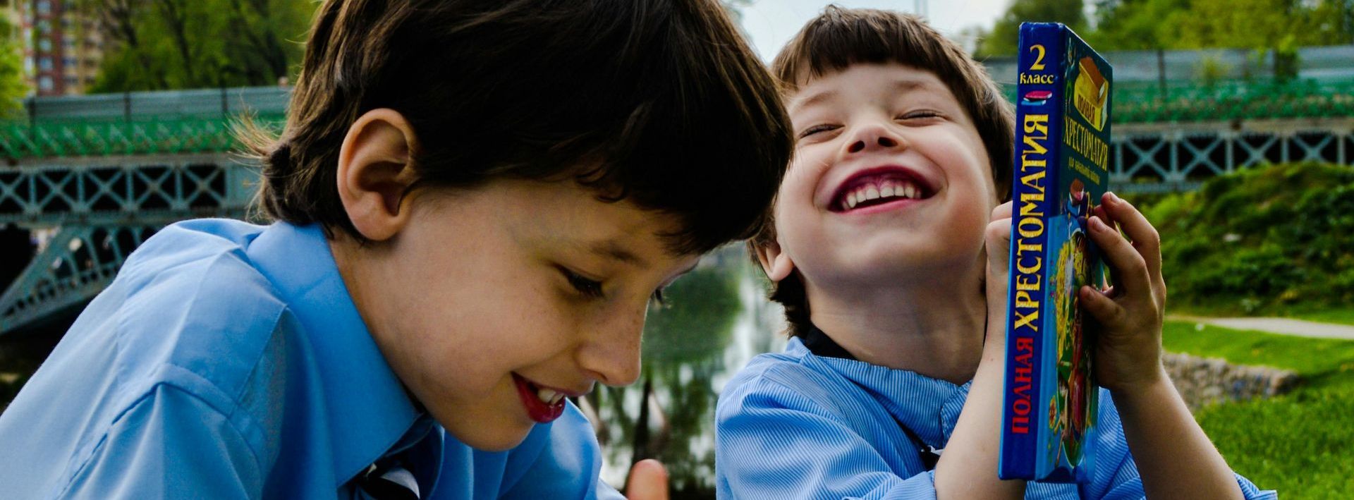 Two young boys are looking at a book called apollo 11