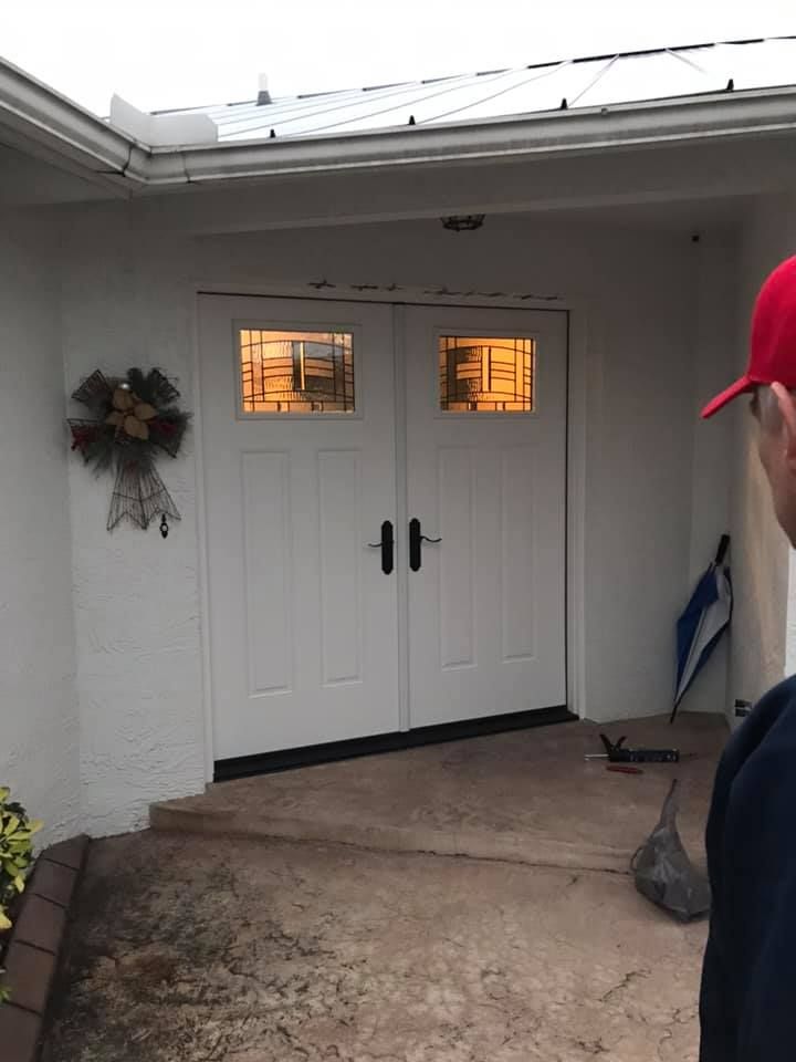 White double doors with glass panels and a man in a red cap.