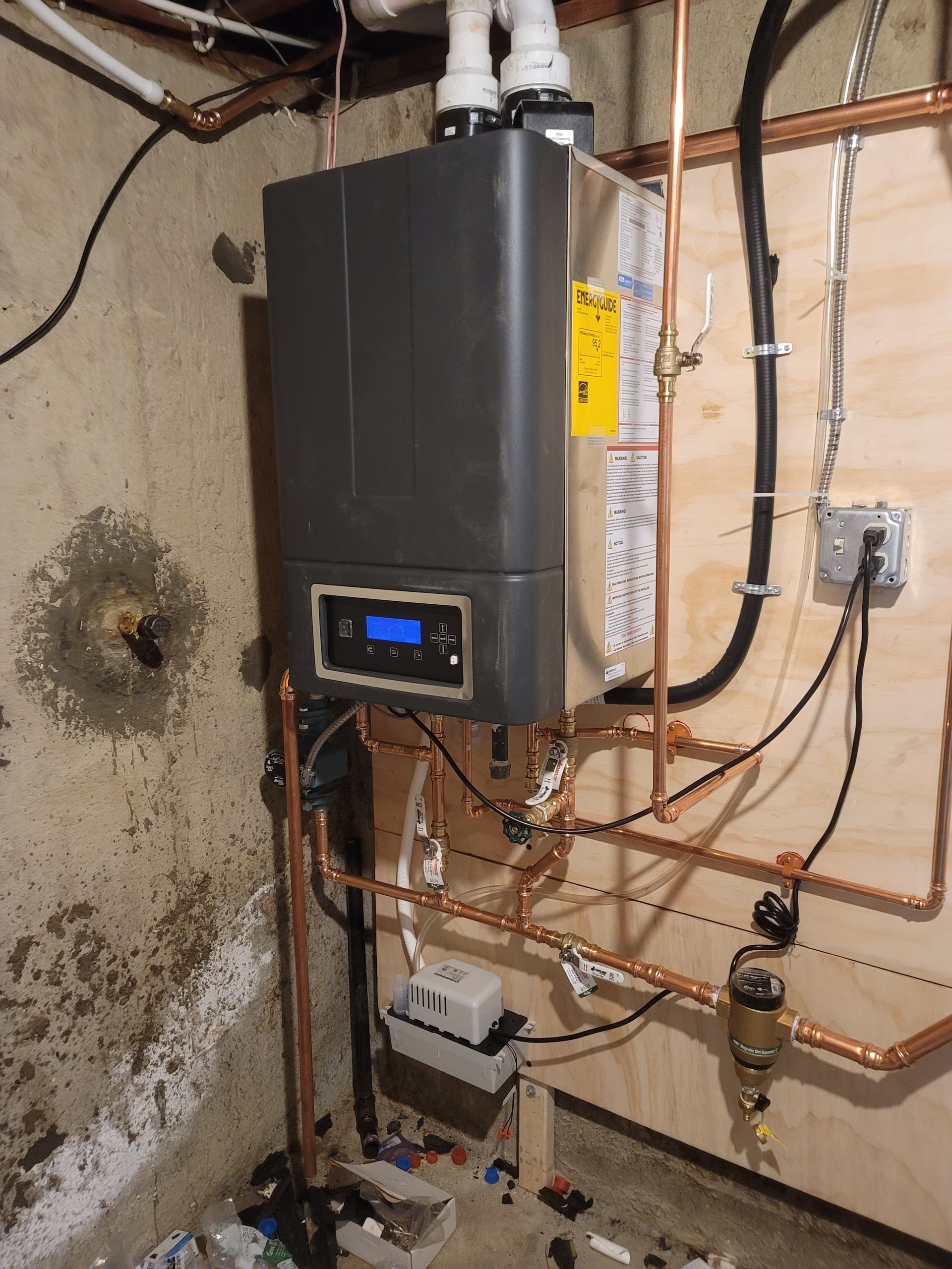 Male plumber repairing boiler with screwdriver in bathroom