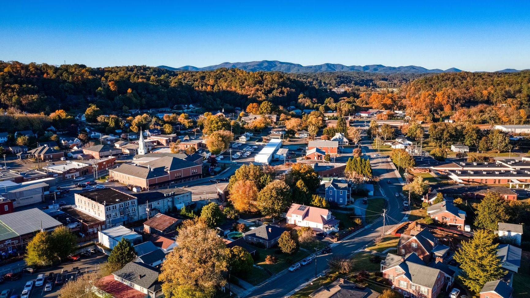 An aerial view of a small town surrounded by trees and buildings.