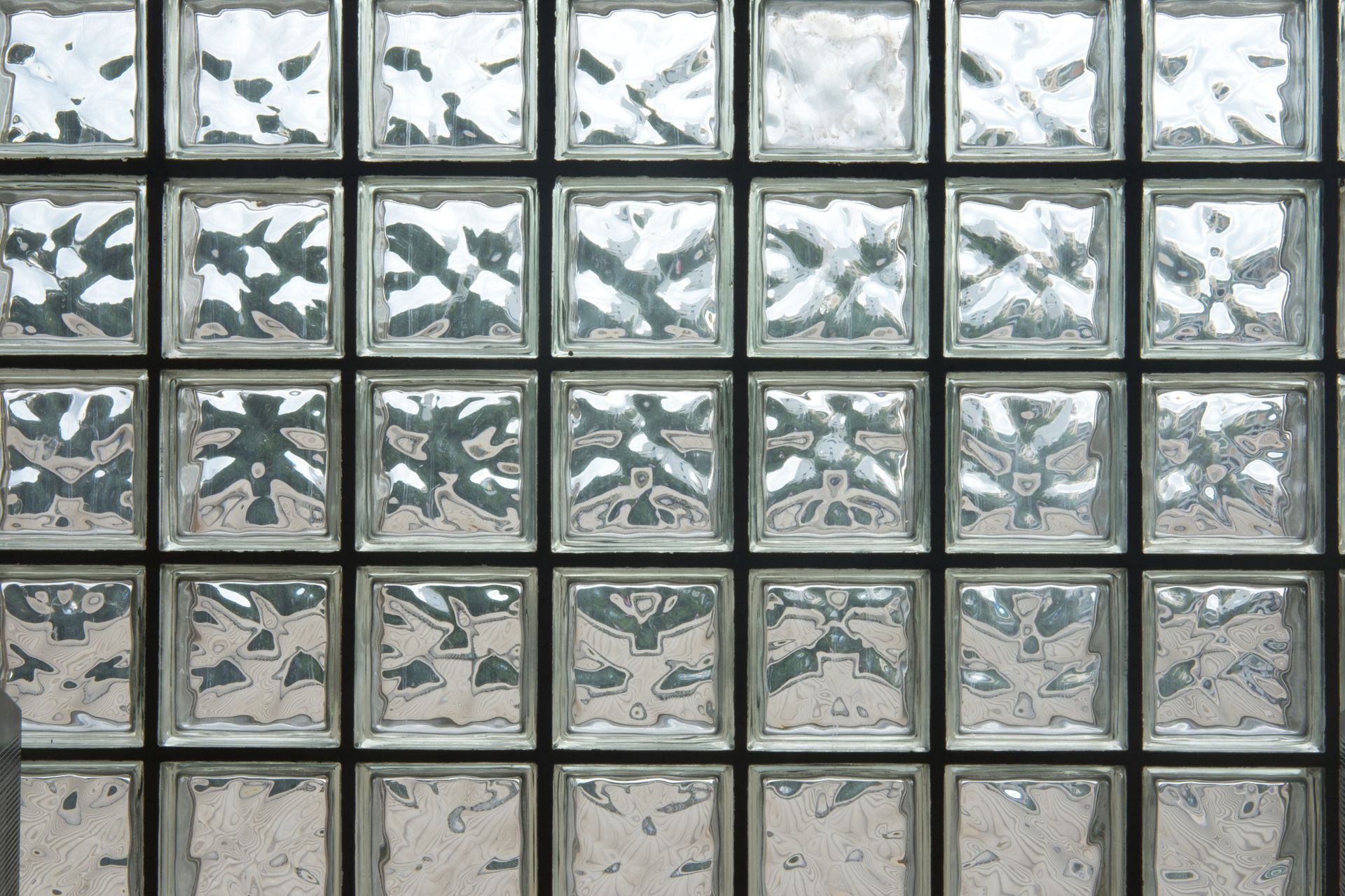 Grid of frosted glass bricks with gray and beige tones in a tiled wall pattern