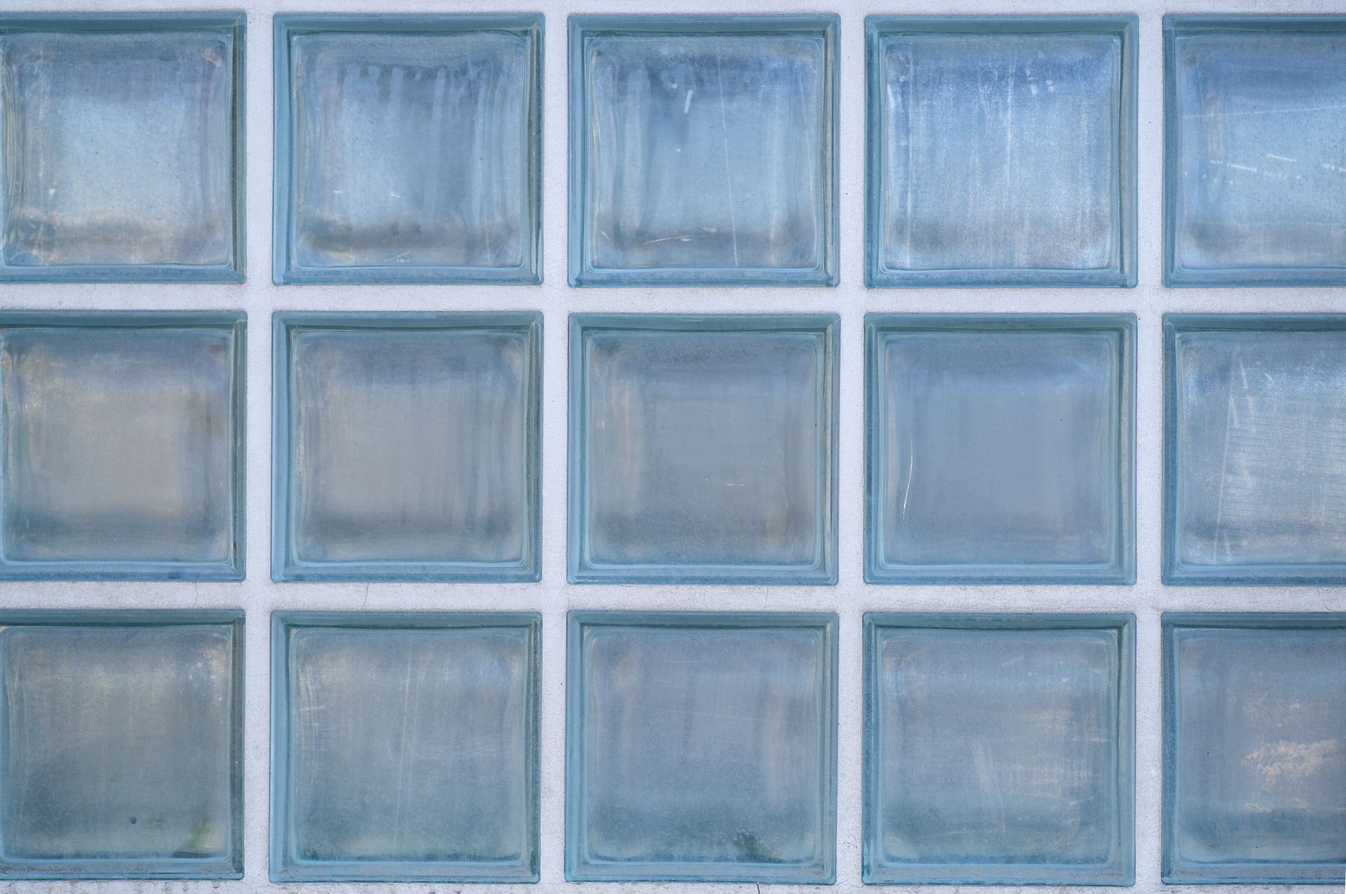 Blue frosted glass tiles arranged in a grid pattern with white grout lines