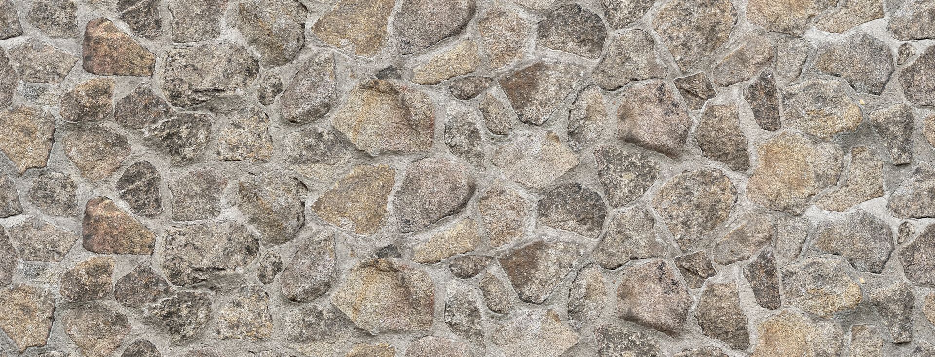 Close-up of a rough gray and tan stone wall texture