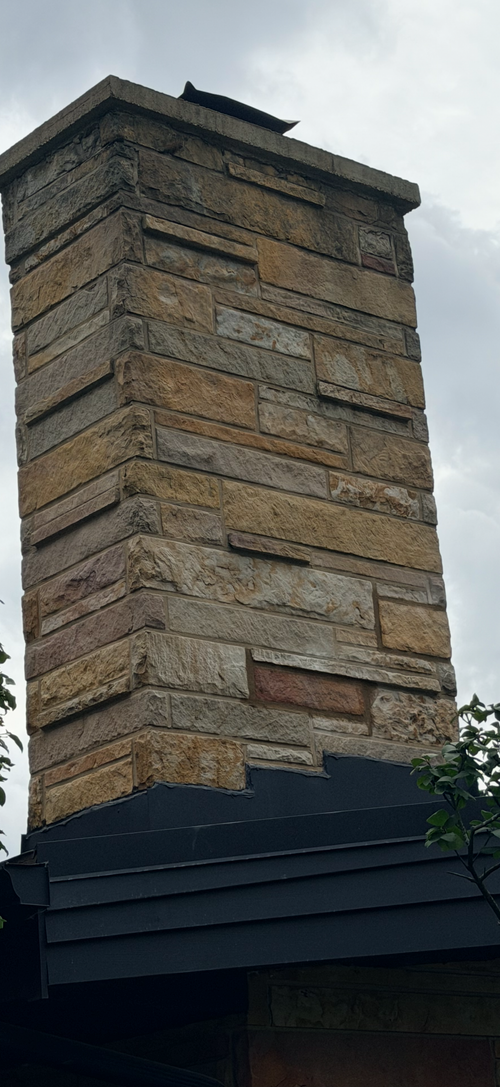 Gray stone wall made of stacked rectangular blocks with rough texture