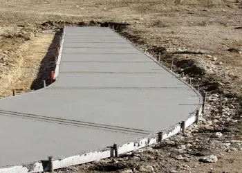 Fresh concrete walkway being poured through a dirt area