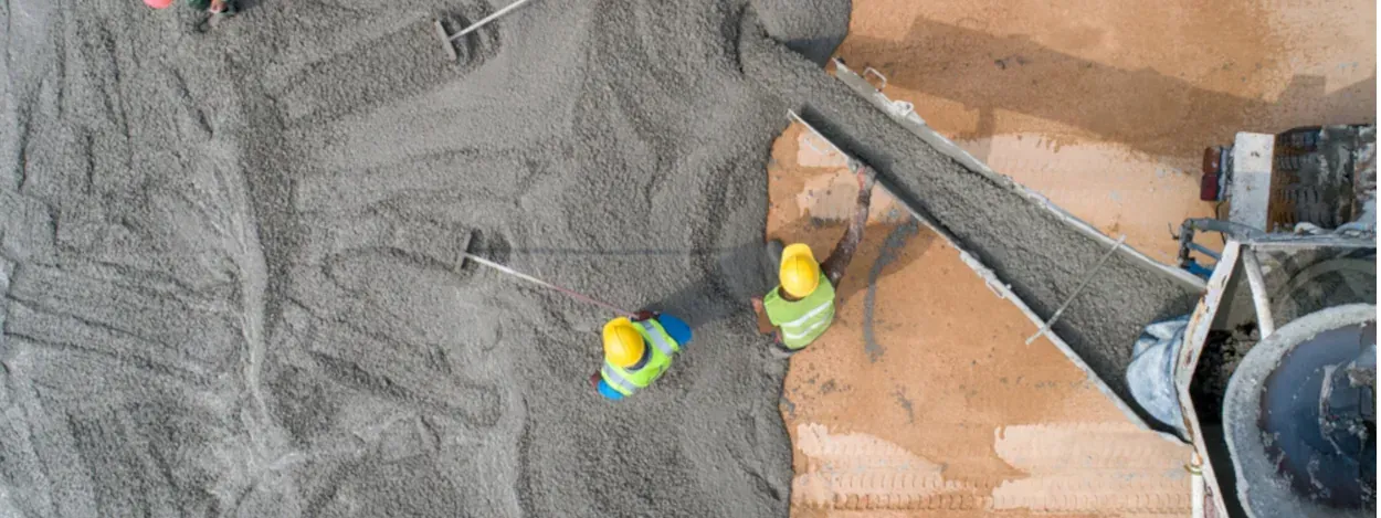 Concrete workers pouring and leveling concrete.