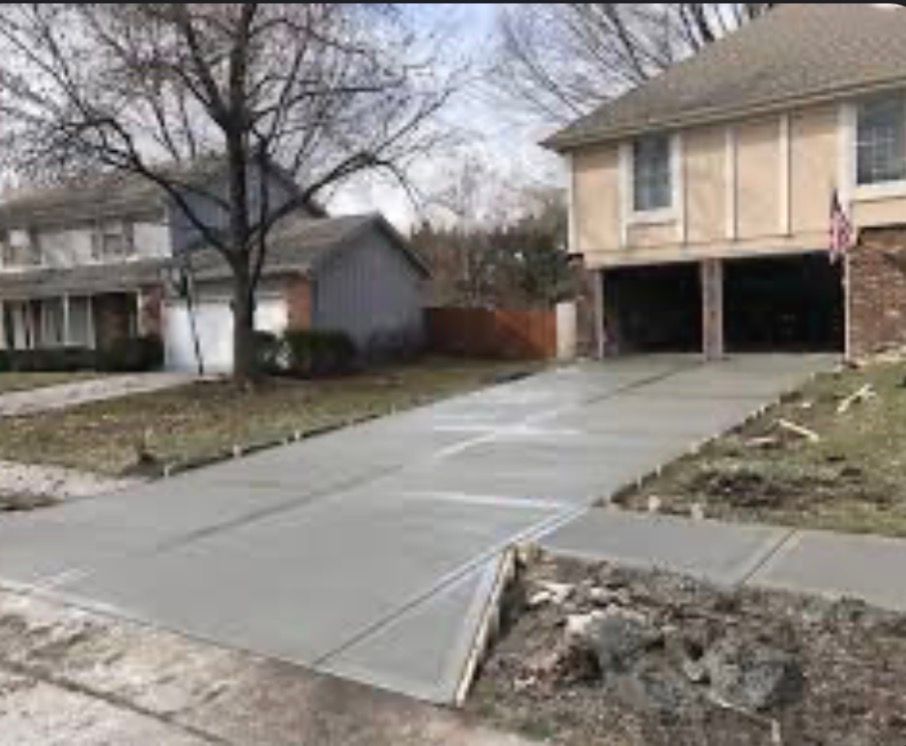 Concrete wheelchair ramp leading to a suburban house’s garage driveway