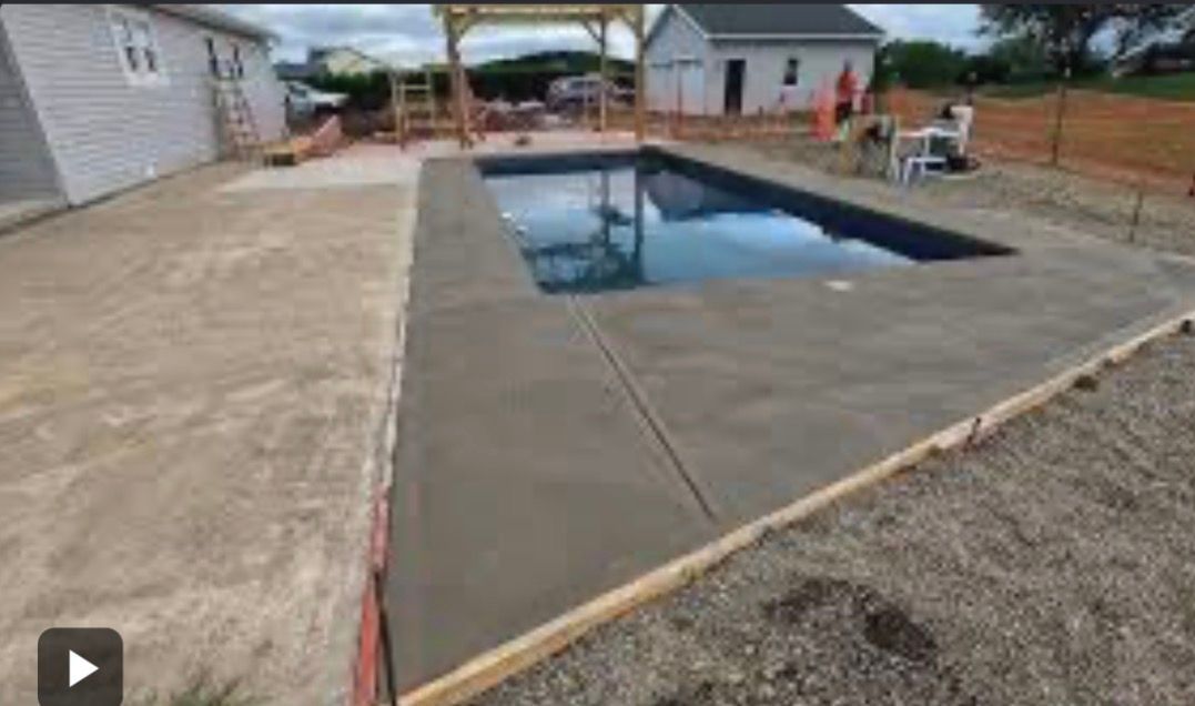 Backyard concrete patio with an in-ground swimming pool under construction