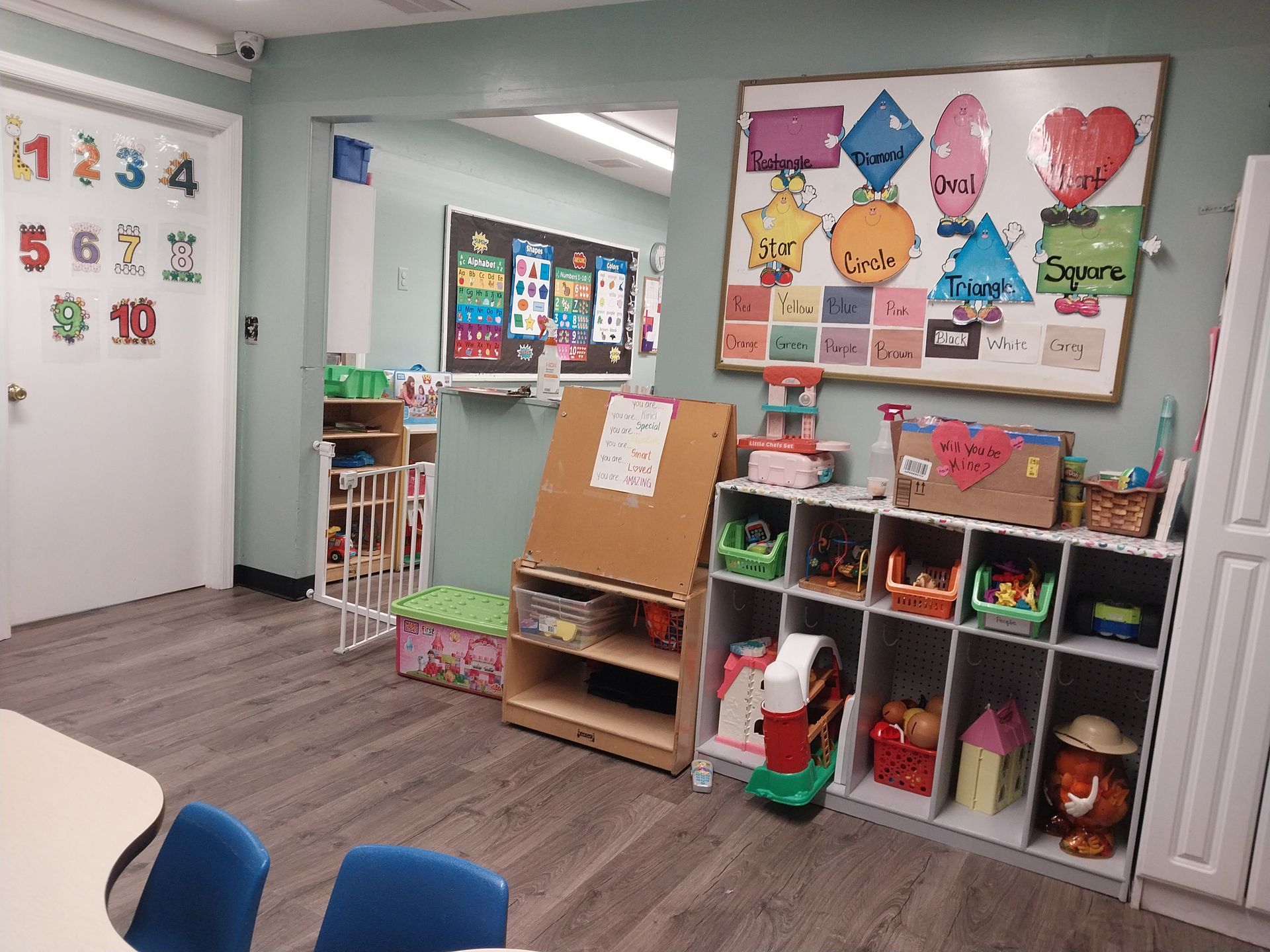 Bright preschool classroom with cubbies, learning posters, and colorful wall decorations