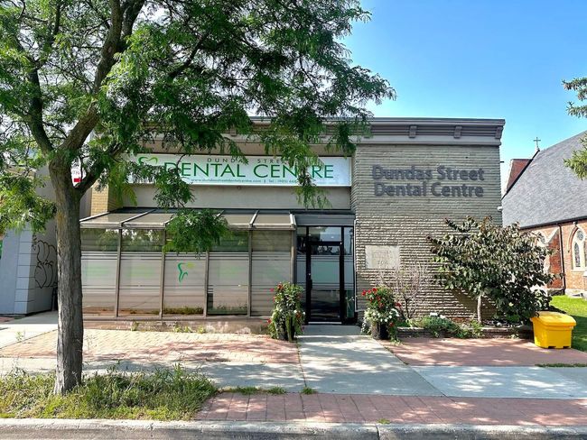 The outside of a dental centre with a tree in front of it.