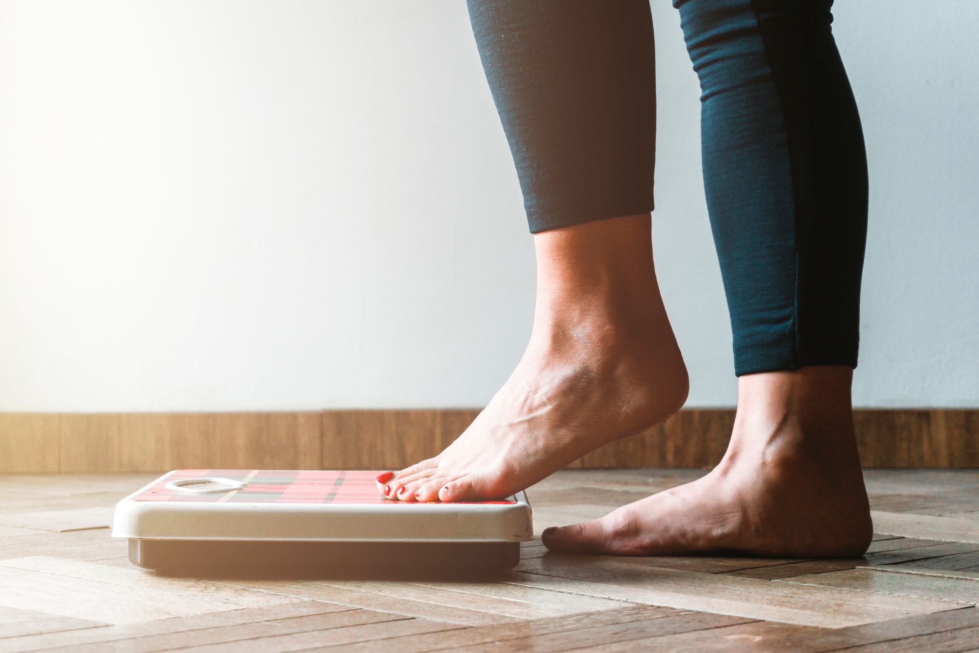 A woman is standing on a scale with her feet on it.