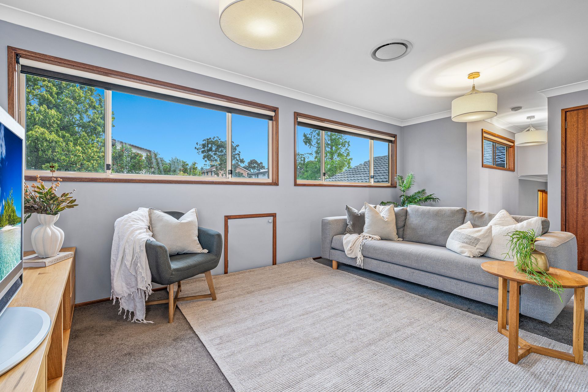 A Living Room With Light Grey Walls, a Grey Sofa, a Matching Armchair — Brightside Buyers Agency in Dundas, NSW