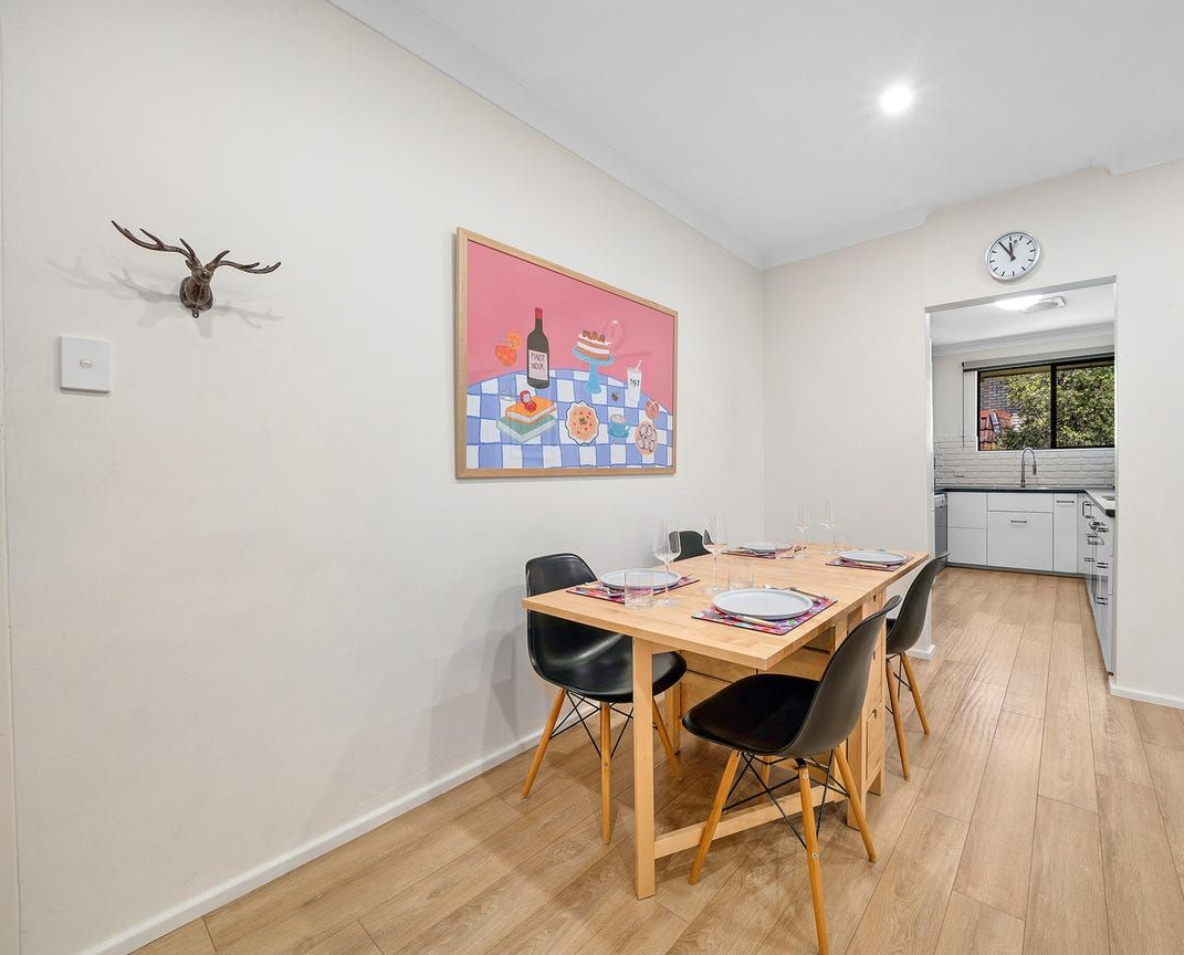A Dining Table With Four Black Chairs, a Framed — Brightside Buyers Agency in Dundas, NSW