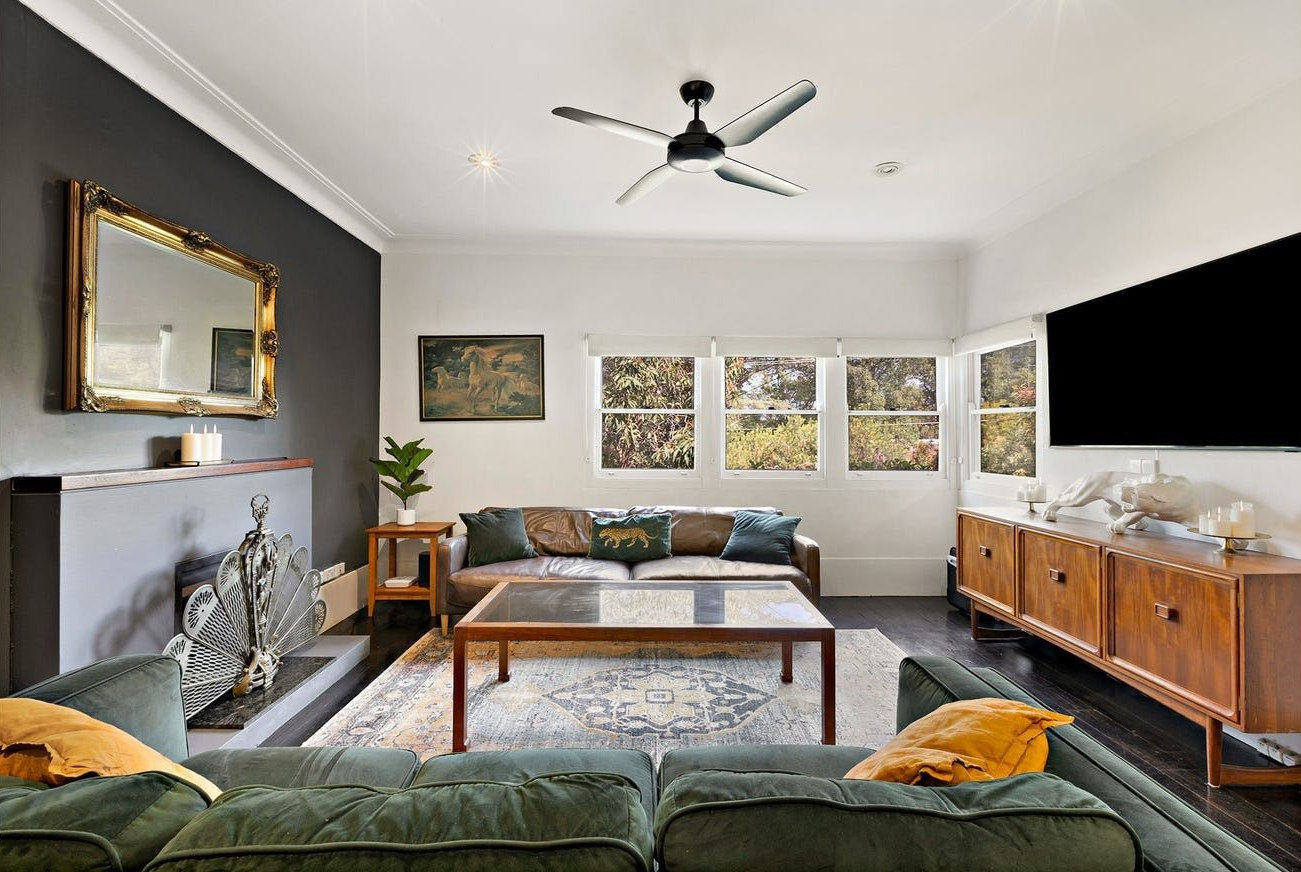A Cozy Living Room With a Green Sofa, Coffee Table, Fireplace — Brightside Buyers Agency in The Hills Shire, NSW