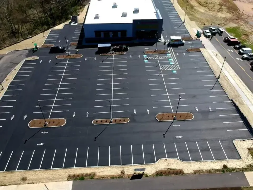 An aerial view of a parking lot with a building in the background