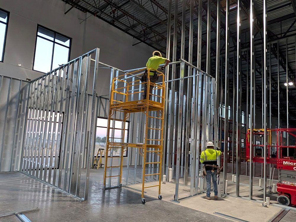 Workers installing metal framing inside a building under construction