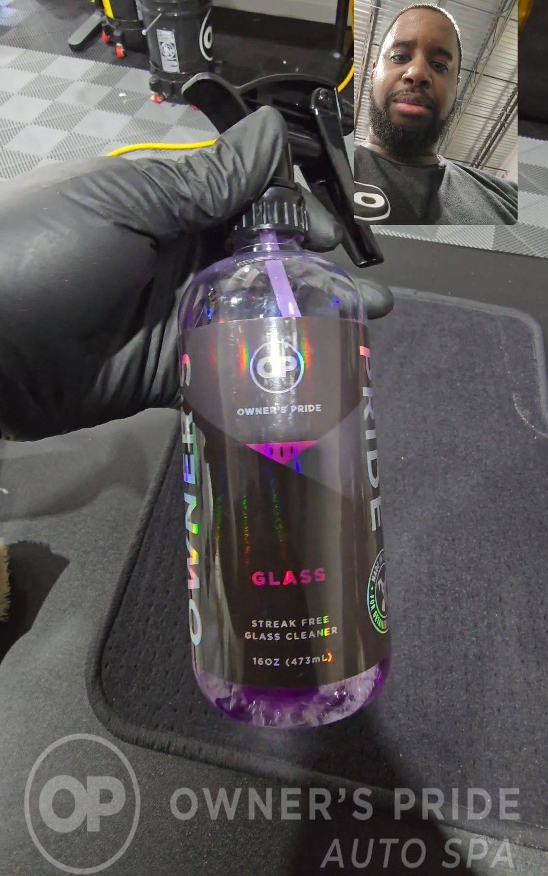 A person is holding a bottle of glass cleaner in their hand.