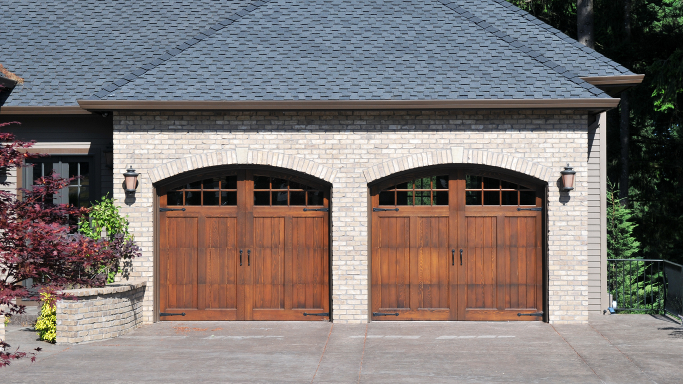 A brick house with two wooden garage doors