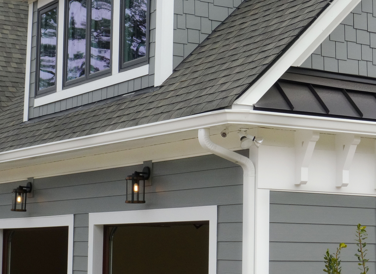 A gray house with a black roof and white trim