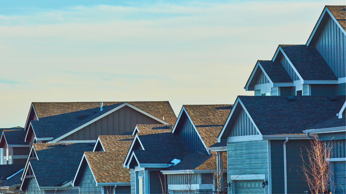 A row of houses with a blue sky in the background.