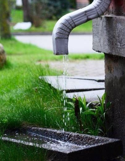 Water is coming out of a faucet in the grass.