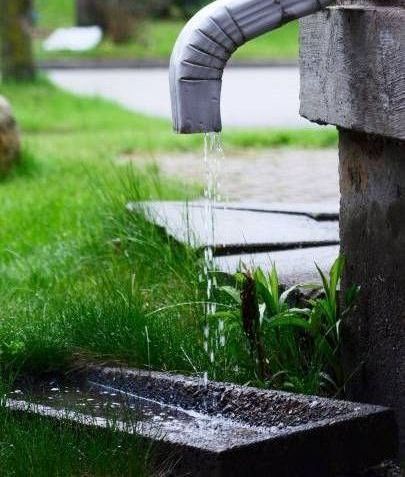 Water is coming out of a faucet in the grass.