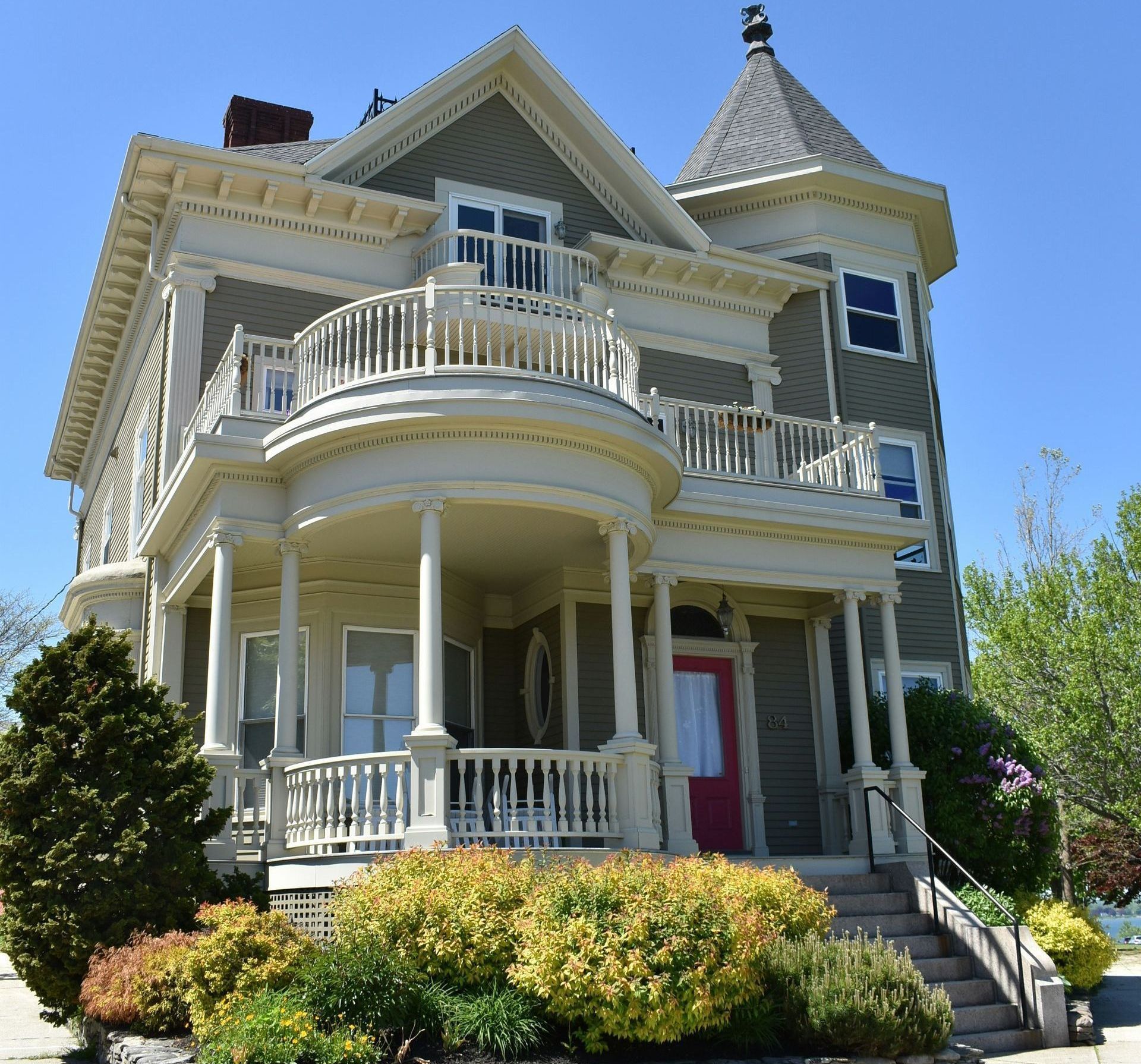 A large house with a balcony and a red door