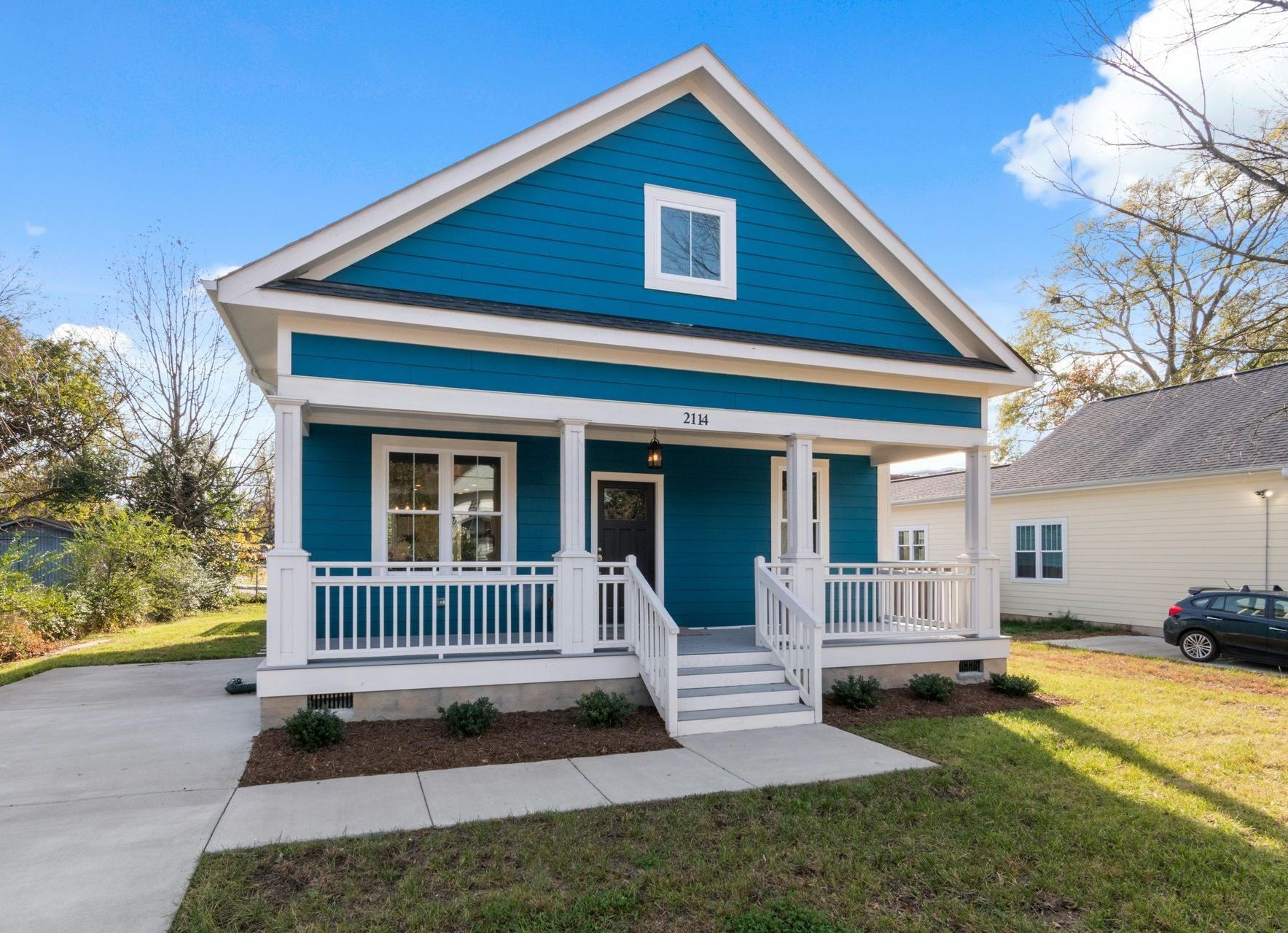 A blue and white house with a porch and stairs