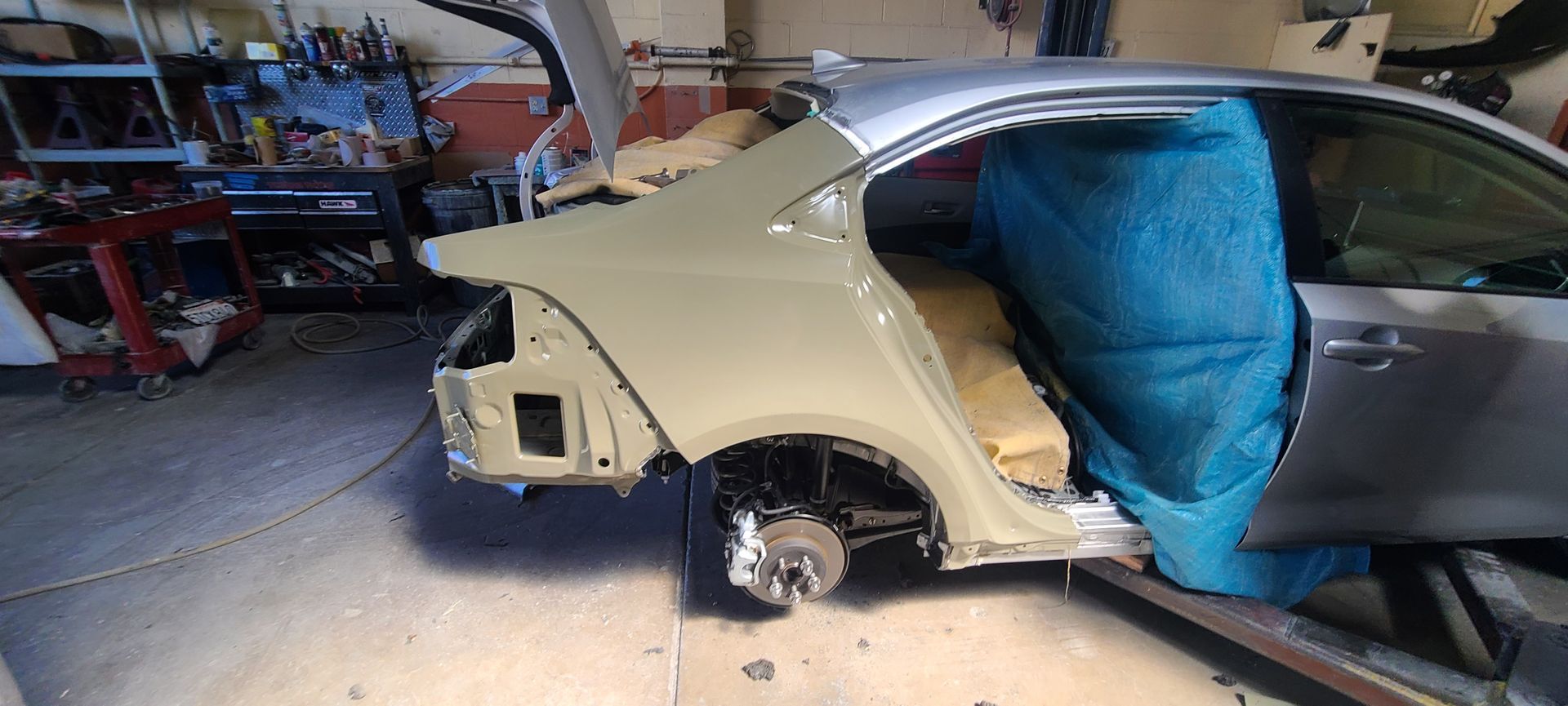 A car is being dismantled in a garage.