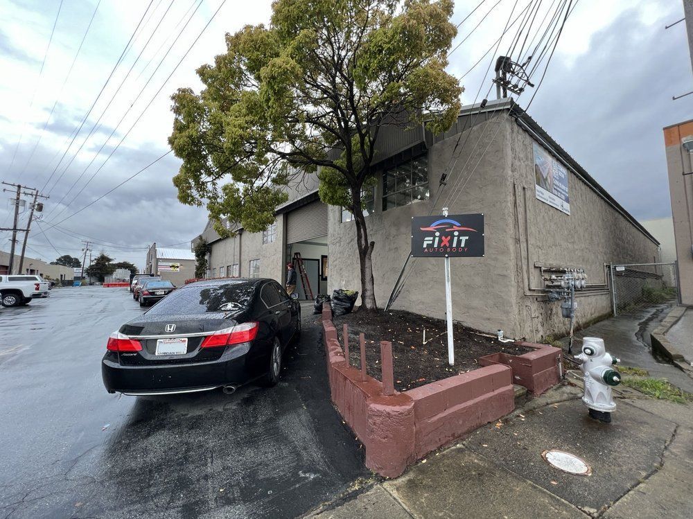 A car is parked in front of a building next to a fire hydrant.