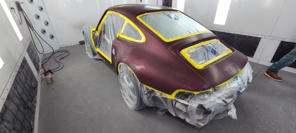 A car is being painted in a paint booth.