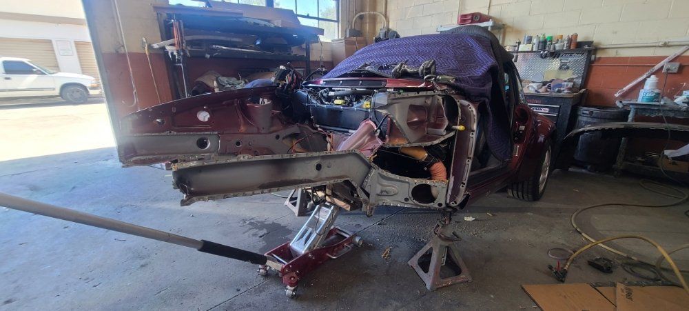 A car is sitting on a jack in a garage.