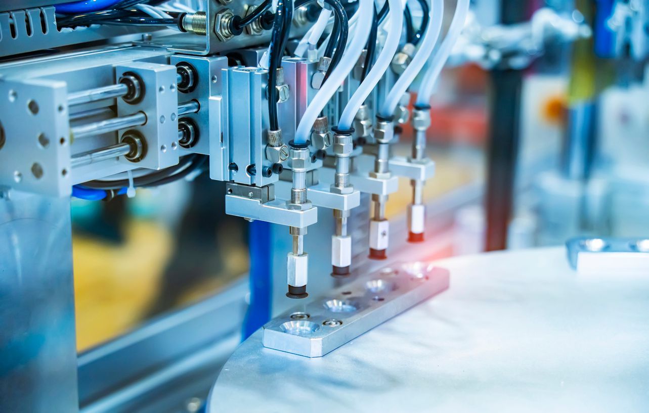 Braço robótico automatizado montando componentes em uma linha de produção de fábrica.