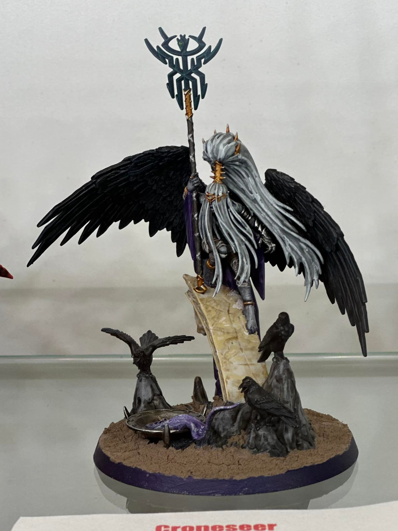 A statue of a man with black wings holding a flag